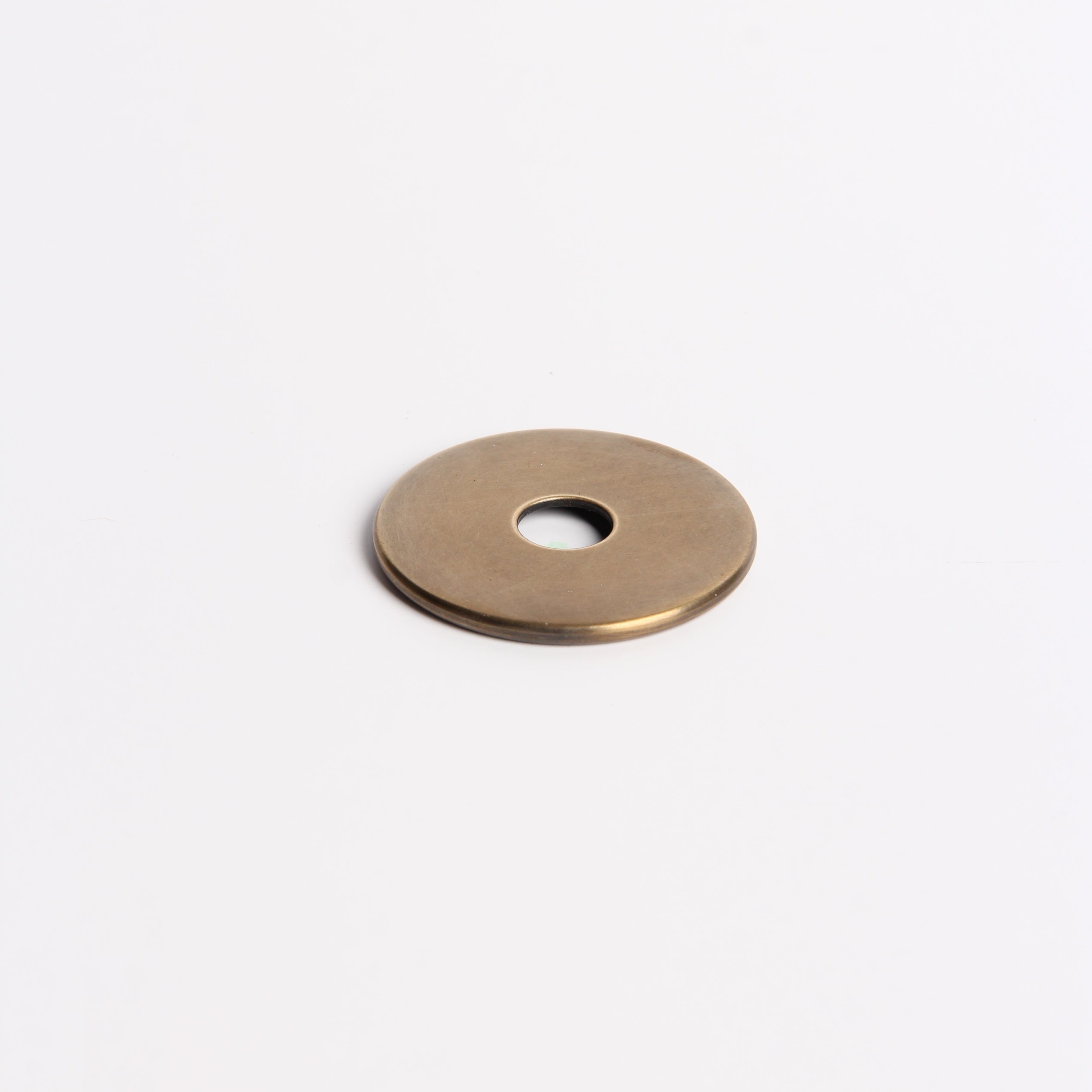 Gold circular object with a central hole on a white background